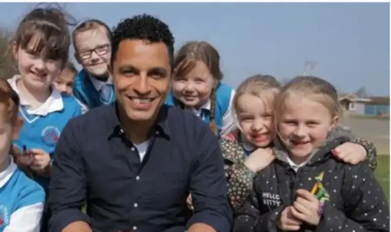 a group of school girls with their male teacher outdoors