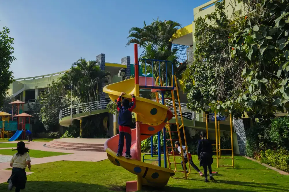 Geography STEM kids out in the playground that's surrounded with trees to provide some cool shade