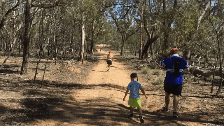 two kids taking a walk with their father