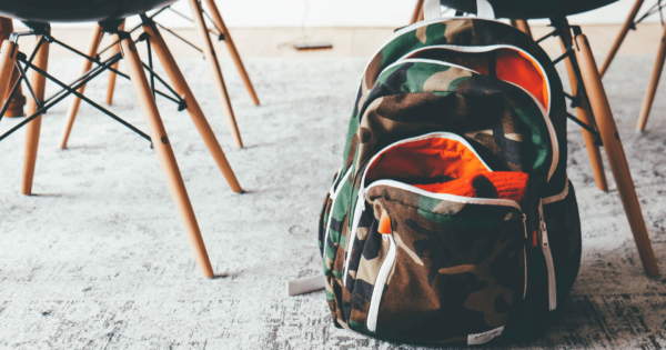 a school backpack sits on the ground in a classroom