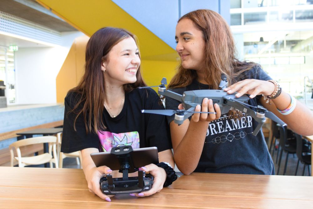 Students smiling with drones