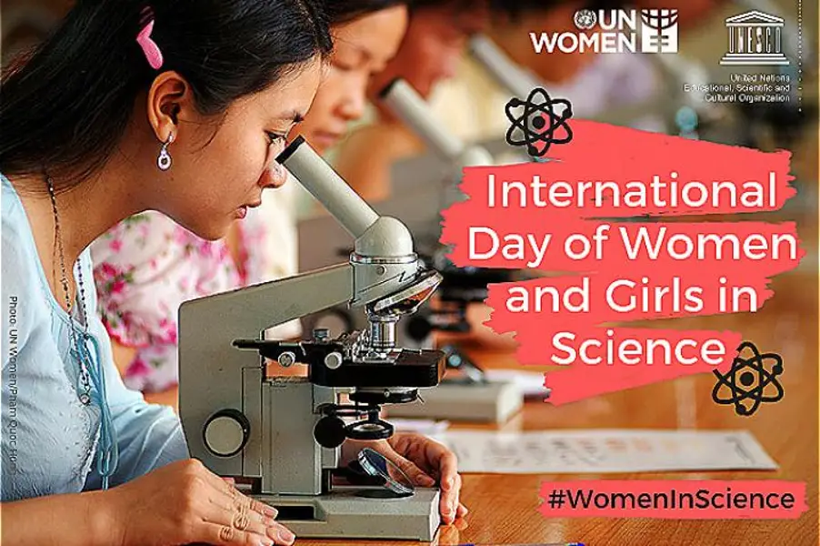a row of girls looking through a microscope