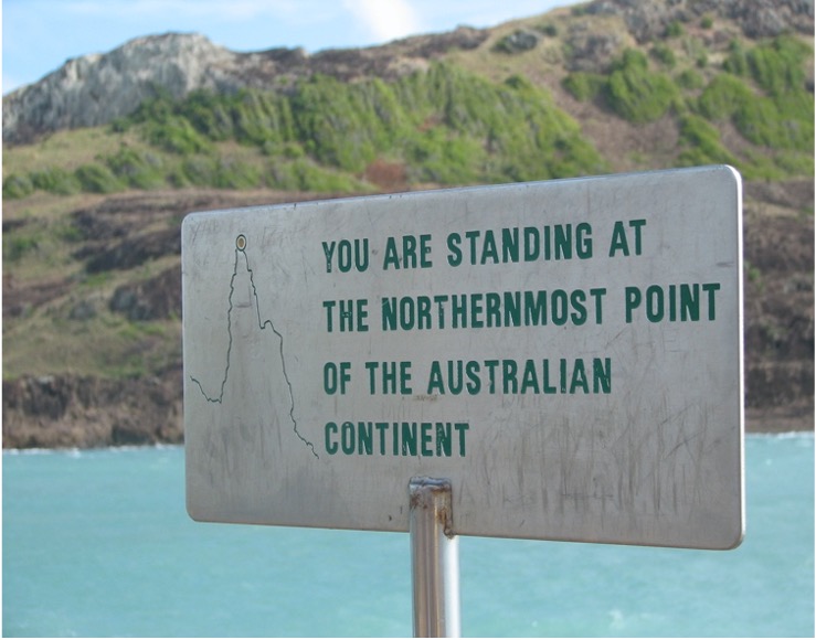 a sign that indicates the location of the background - the northernmost point of the Australian continent