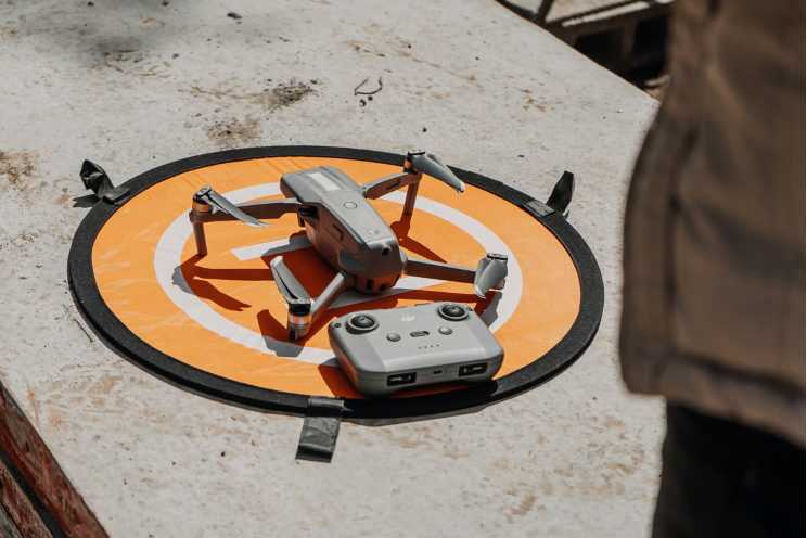 a drone and controller on top of an orange launch pad