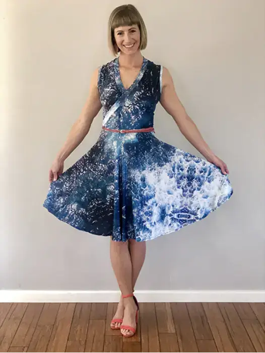 a woman wearing a dress with an image of the ocean captured by a drone