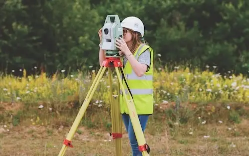 Woman using a surveying instrument outdoors