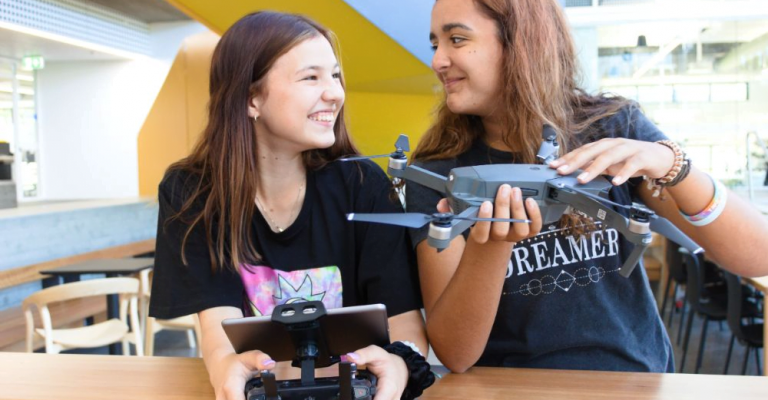 female students with pieces of drone equipment